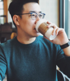 Team member Number 3-Asian man wearing glasses and drinking coffee